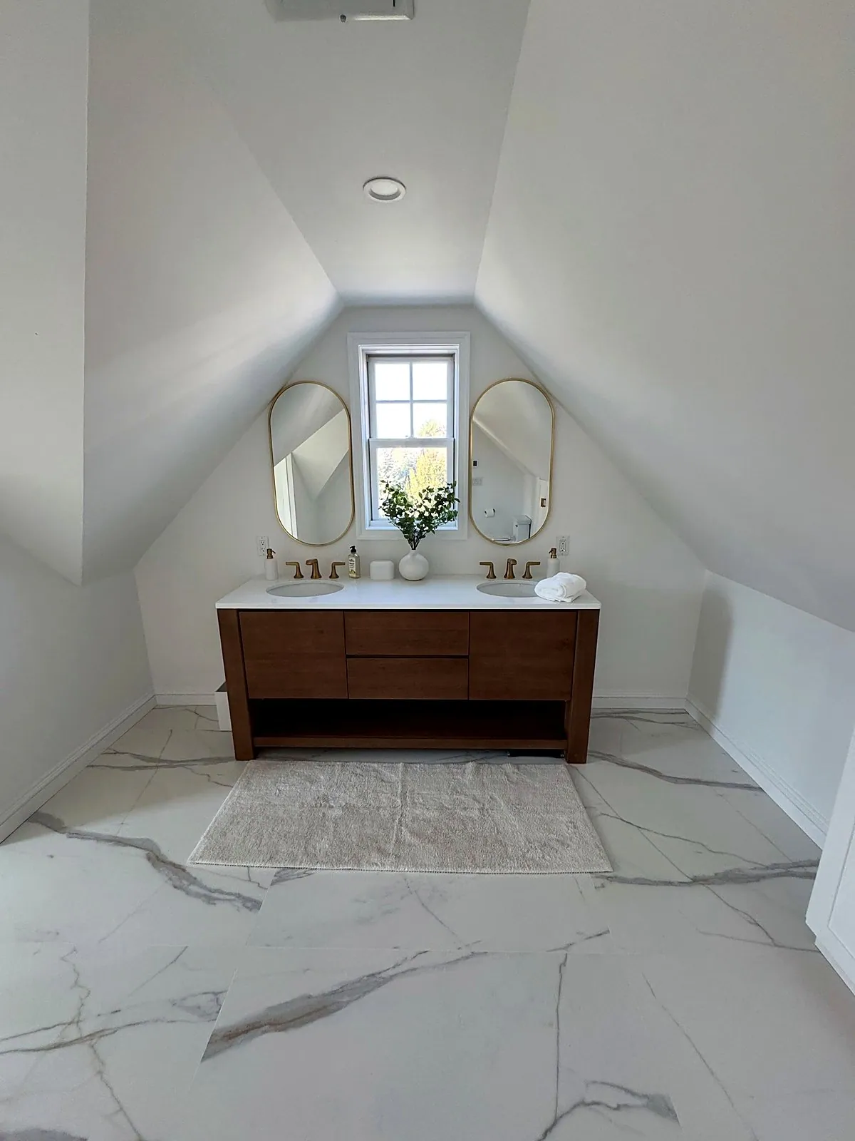 Attic bathroom with a walnut double vanity under a sloped ceiling