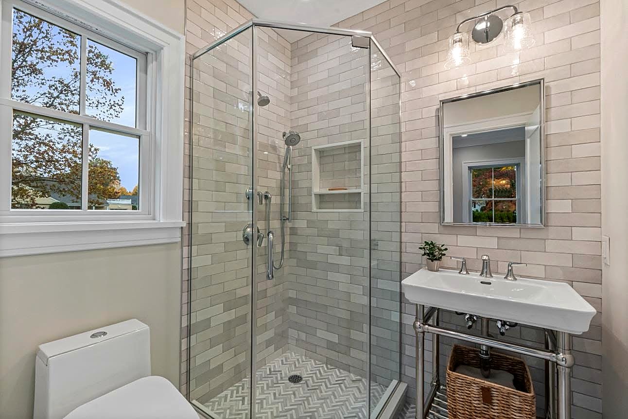 Bright bathroom with a glass corner shower and a console sink