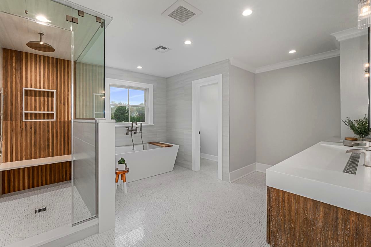 Primary bath with a freestanding tub, a wood slat shower wall, and mosaic tile floors