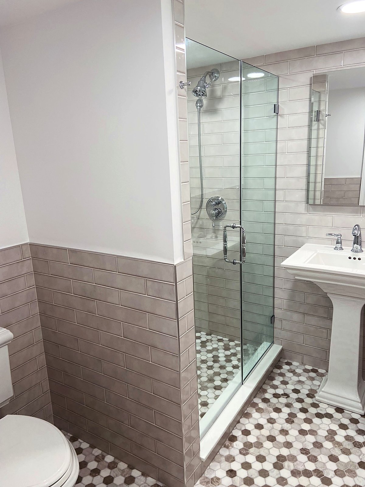 Bathroom with taupe subway tile walls and a marble hexagon floor