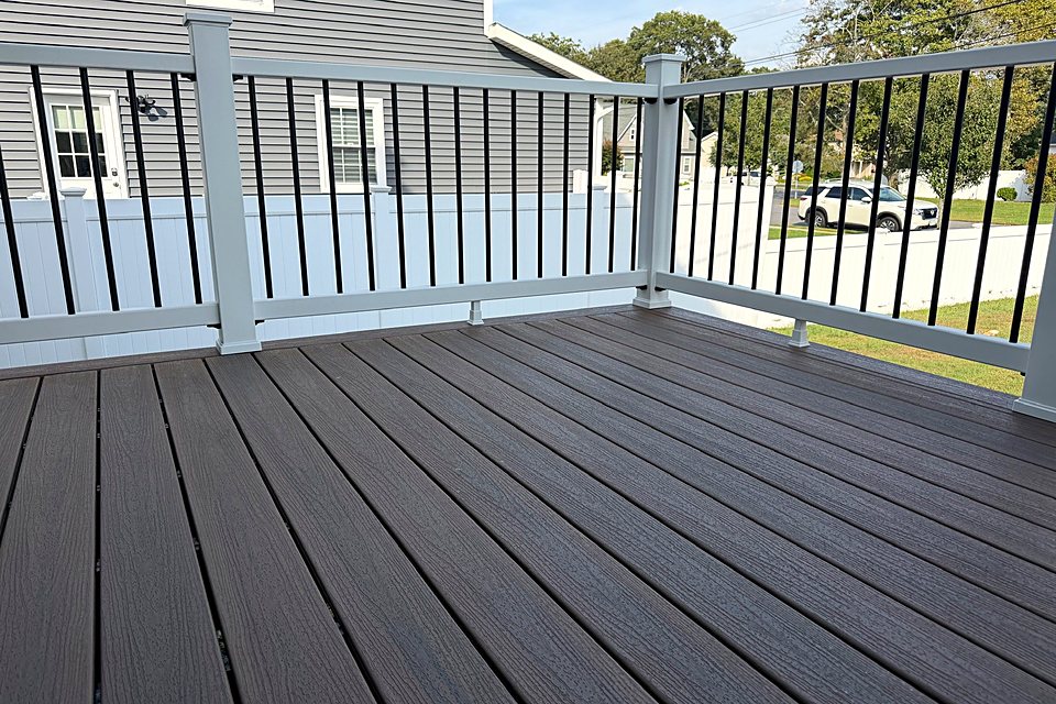 Composite porch deck with white posts and black balusters
