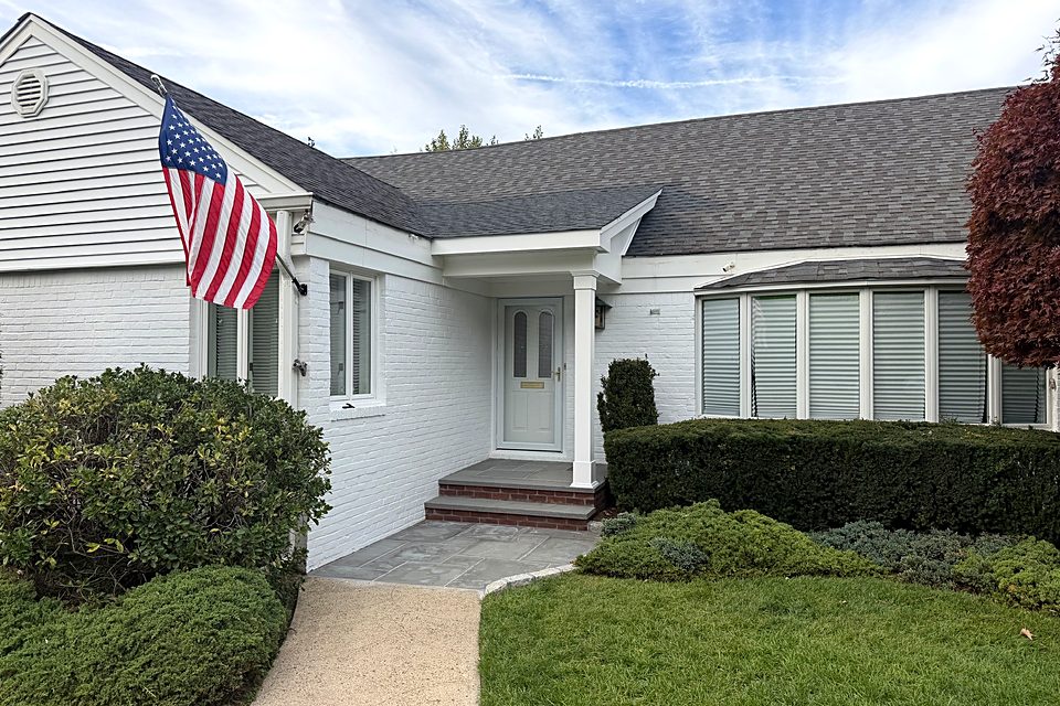 From the street: The house with the new front portico and boxwood hedges.