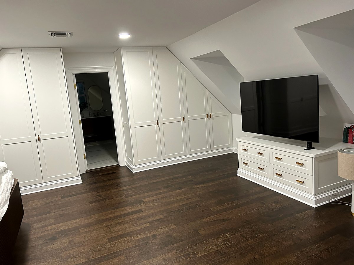 Built-in media wall and drawer bank fitted under a sloped eave