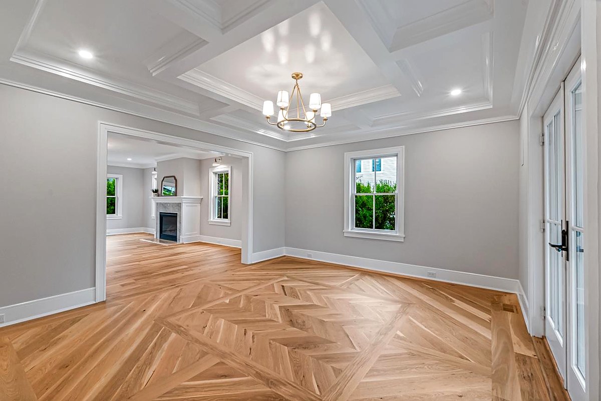 Dining room with a coffered ceiling, a chandelier, and herringbone floors