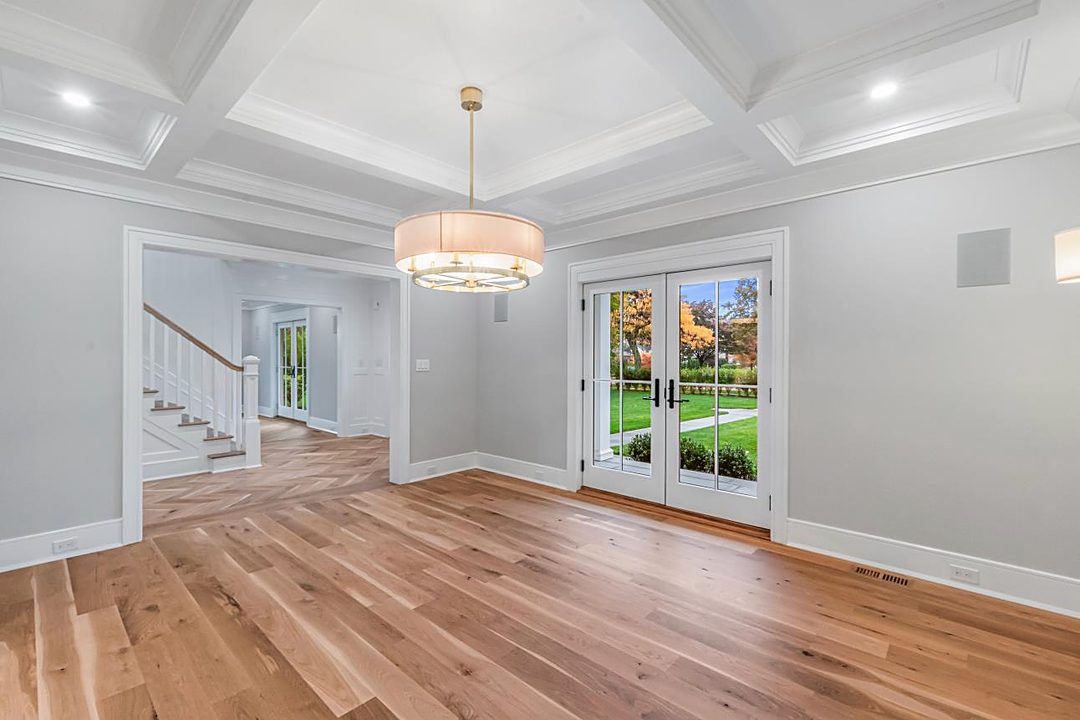 Room with a coffered ceiling, a drum pendant, French doors, and a view to the staircase