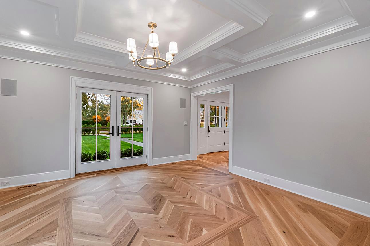 Dining room with a coffered ceiling, French doors to the yard, and a brass chandelier