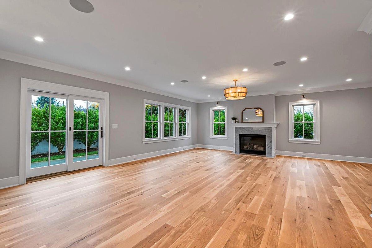 Great room with a fireplace, tall windows, and white oak floors