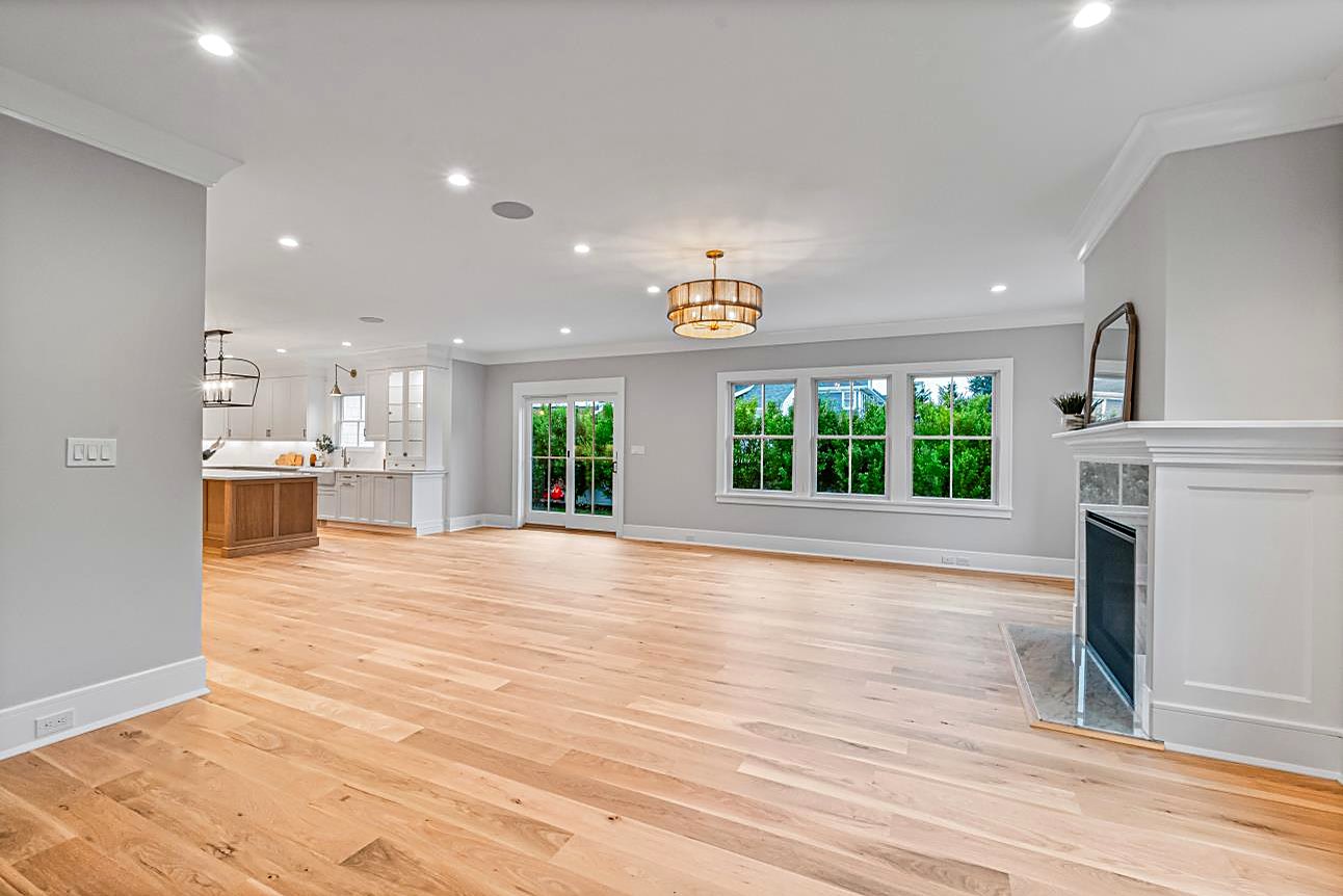 Open great room with a marble fireplace, recessed lighting, and wide-plank floors