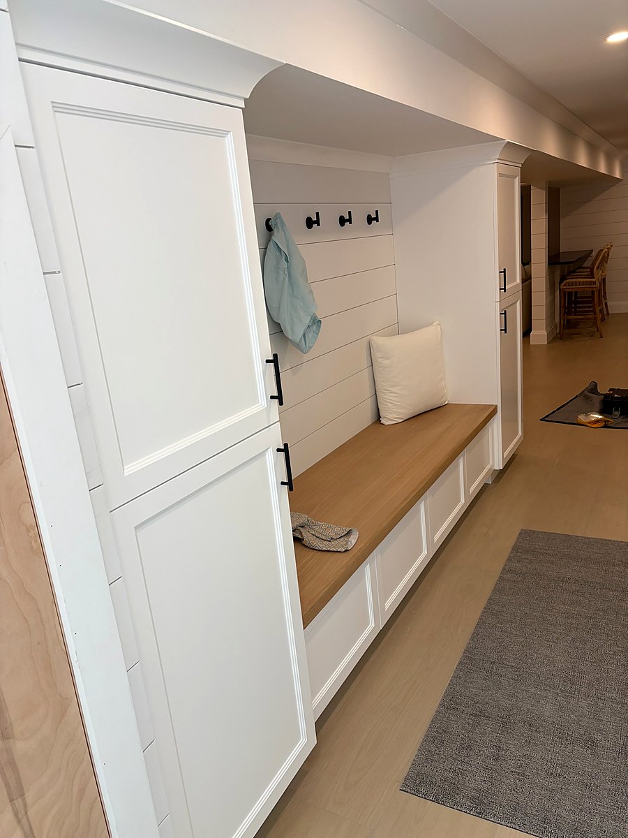 Mudroom with a built-in bench, coat hooks, and paneled storage