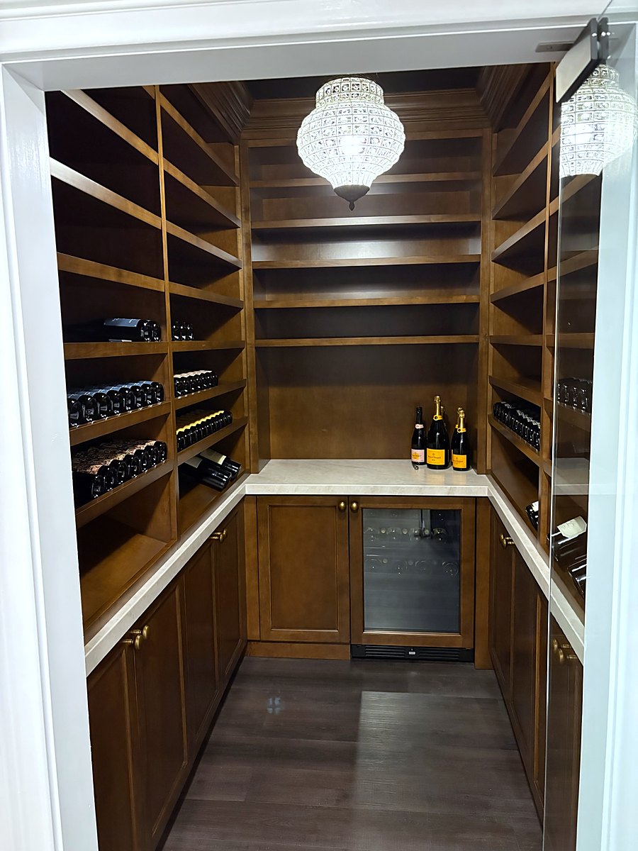 Wine room with floor to ceiling white oak racking and a stone counter
