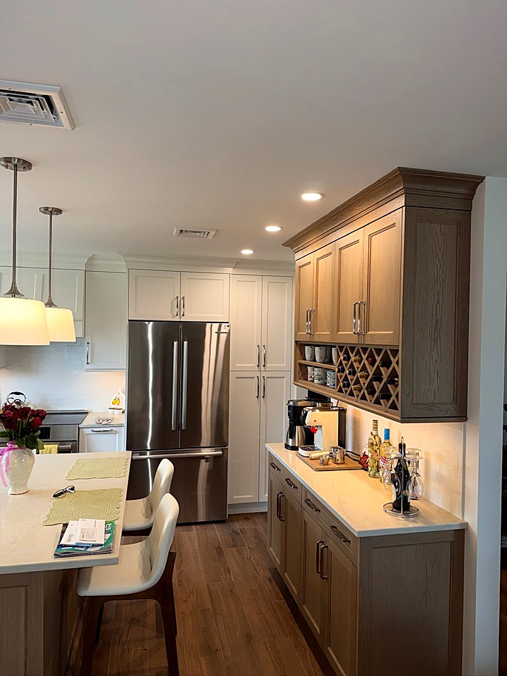 Kitchen with greige cabinetry, a built-in wine rack, and a stainless refrigerator