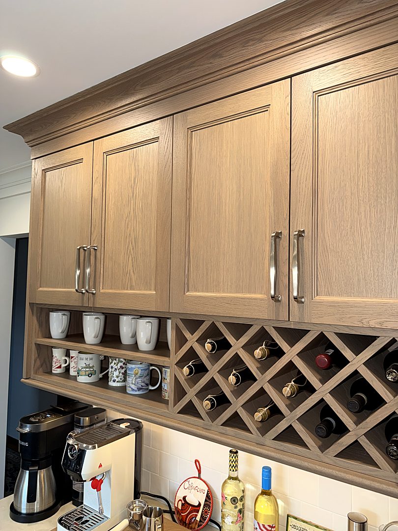 White oak upper cabinets with a built-in lattice wine rack and an open mug shelf