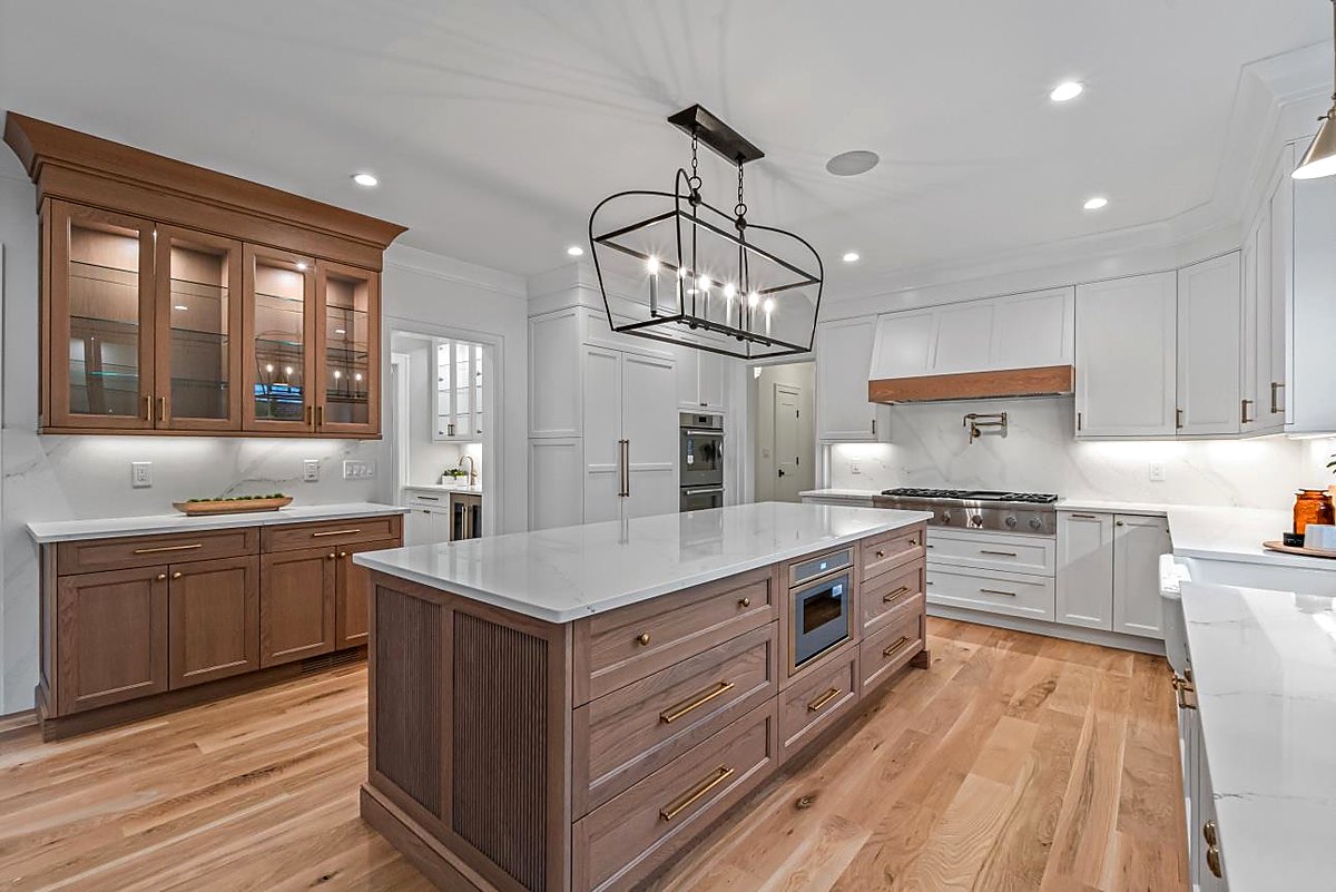 Walnut island with lantern pendants and glass front upper cabinets