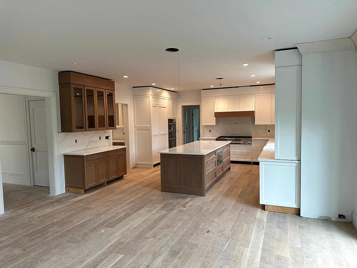Kitchen with a walnut island, white perimeter cabinetry, and quartz counters