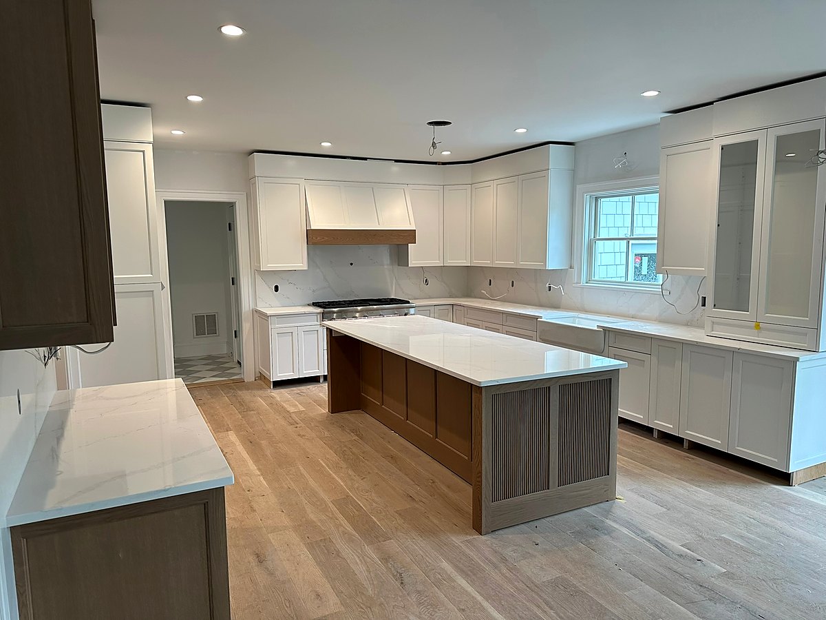Kitchen with a waterfall edge island and a paneled range wall