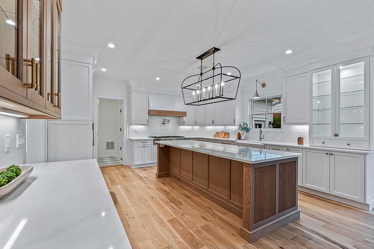 Bright kitchen with glass front cabinets, a fluted walnut island, and quartz counters