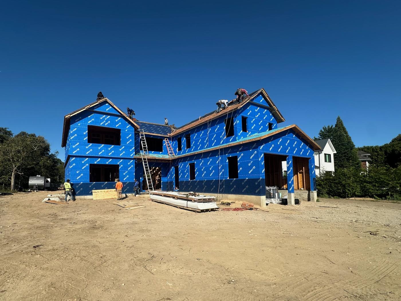 Fully wrapped: The whole house wrapped in Henry Blueskin VP100, with crew and ladders on site.
