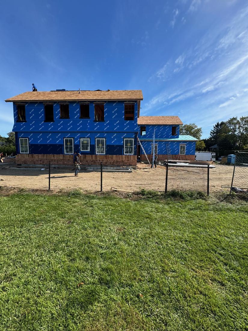 Windows going in: Windows in along the first floor, seen from the yard.
