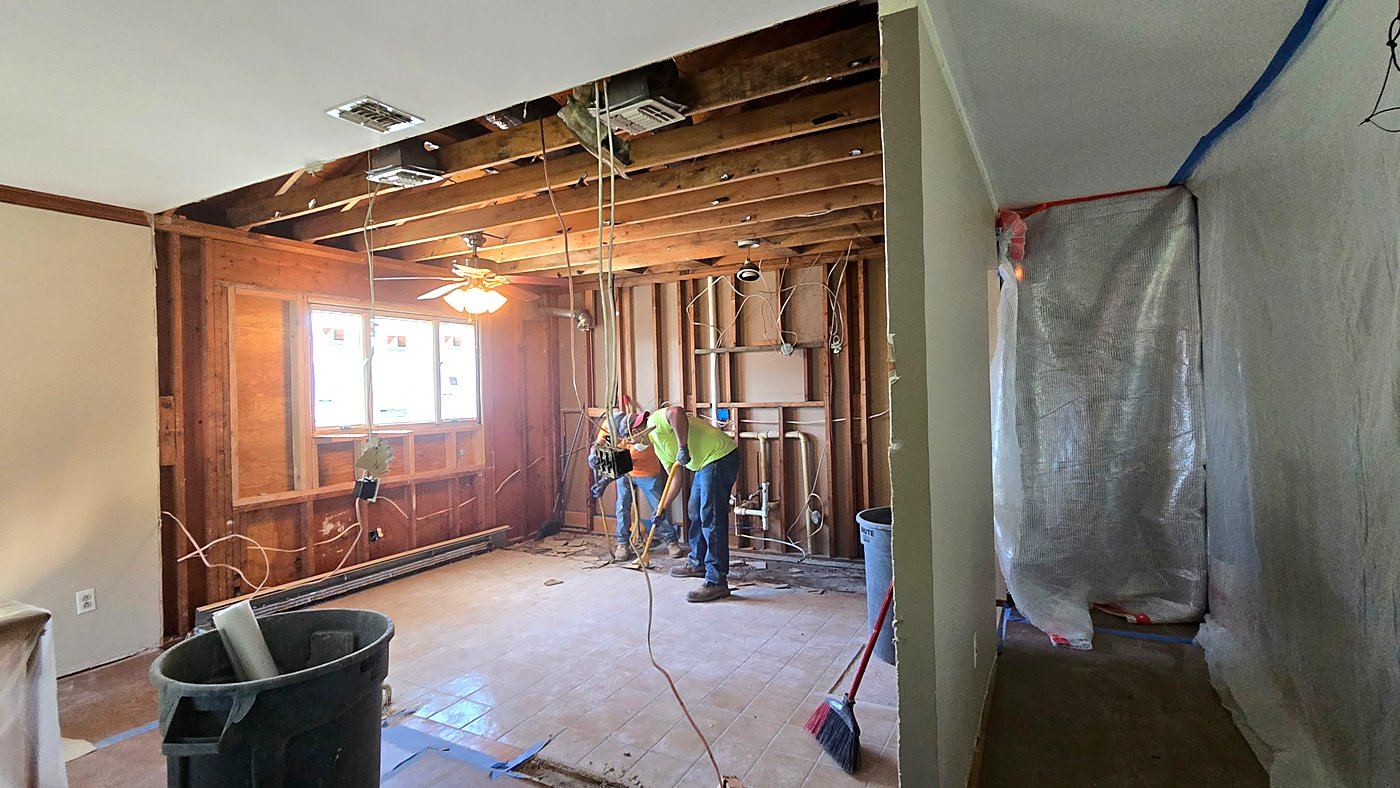 Gutted: Kitchen opened to the studs and ceiling joists while the crew clears debris.