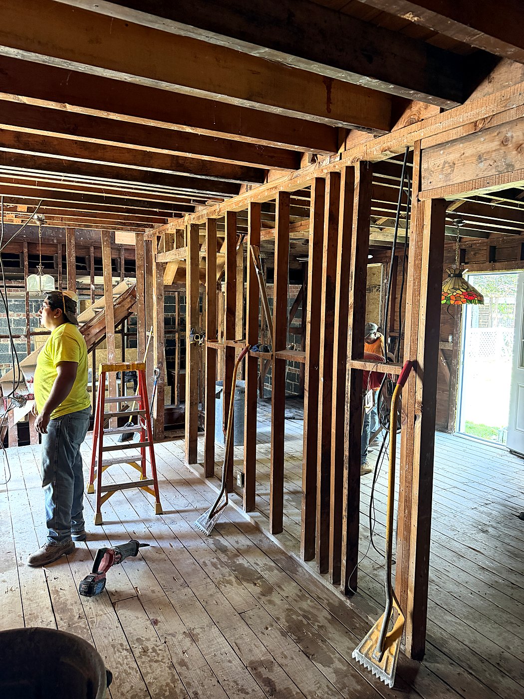 Crew member during interior demolition down to the framing