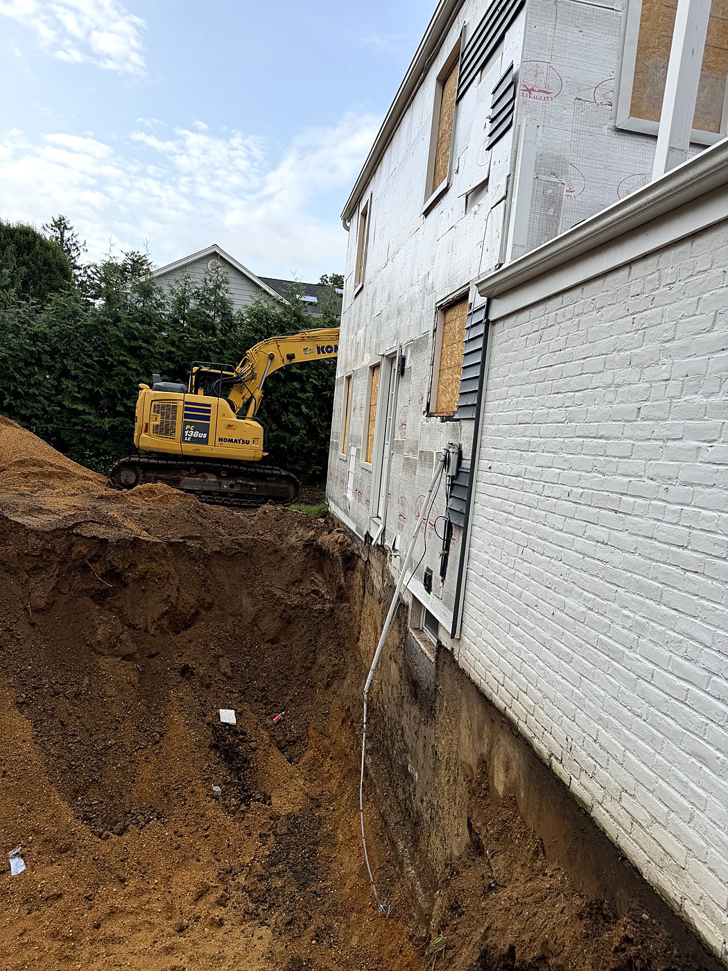 Excavator digging out the foundation for the home addition