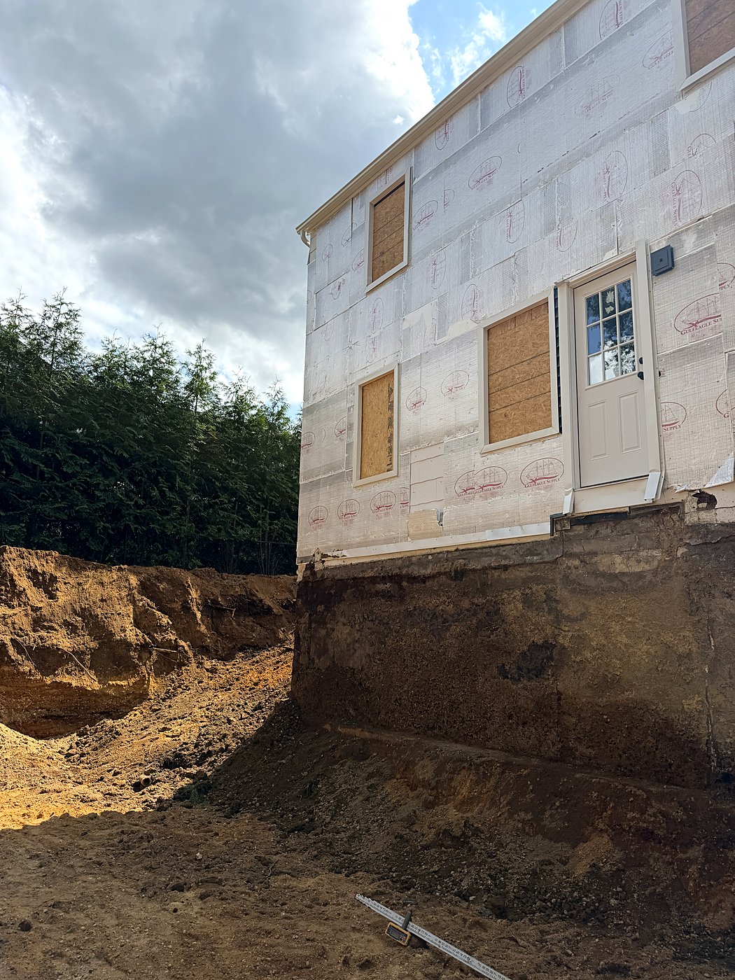 Deep foundation excavation against the existing house wall