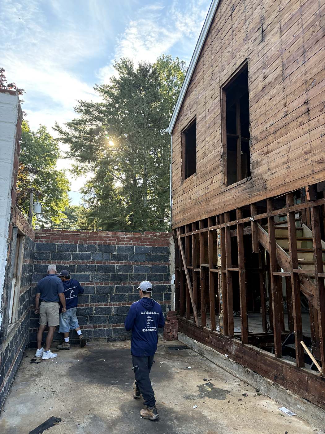Crew reviewing the new block wall where the extension meets the original framing