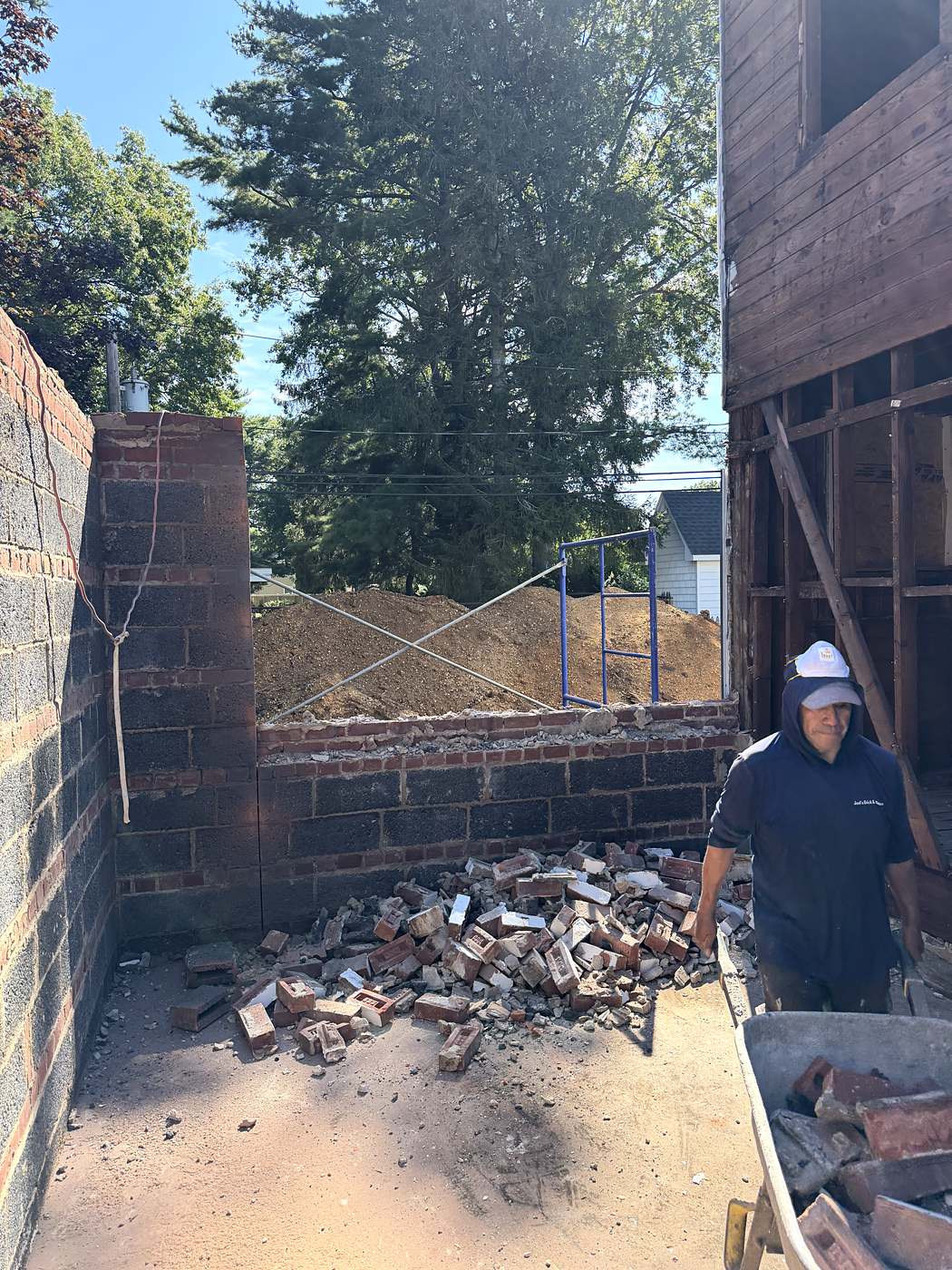 New block foundation wall built up alongside the existing brick chimney