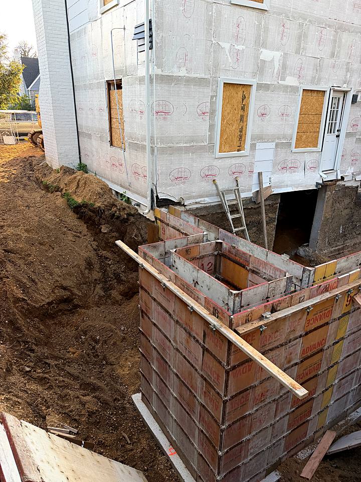 Concrete wall forms set against the house for the new foundation