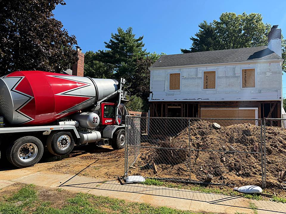 Concrete mixer truck on site beside the house during the foundation work