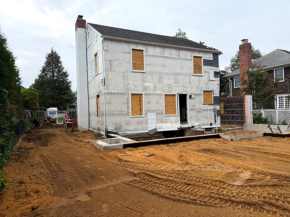 House wrapped in rigid insulation sitting on its new foundation