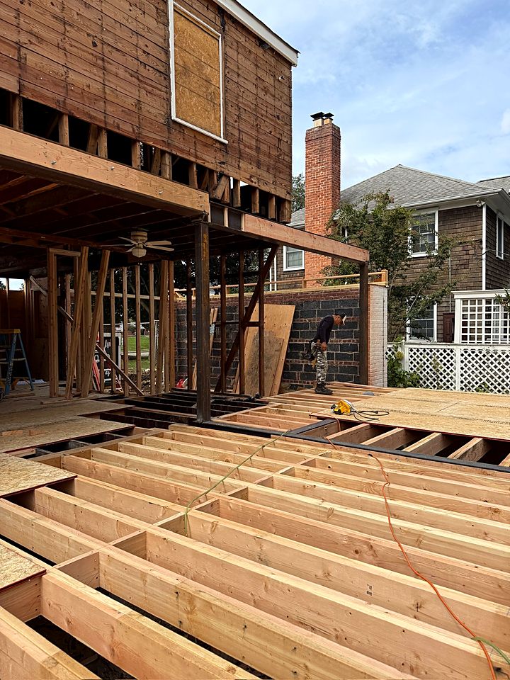 New floor joists framed out over the foundation behind the house