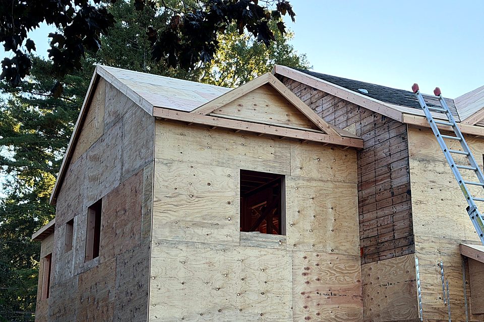 Side of the house sheathed up to the new roofline