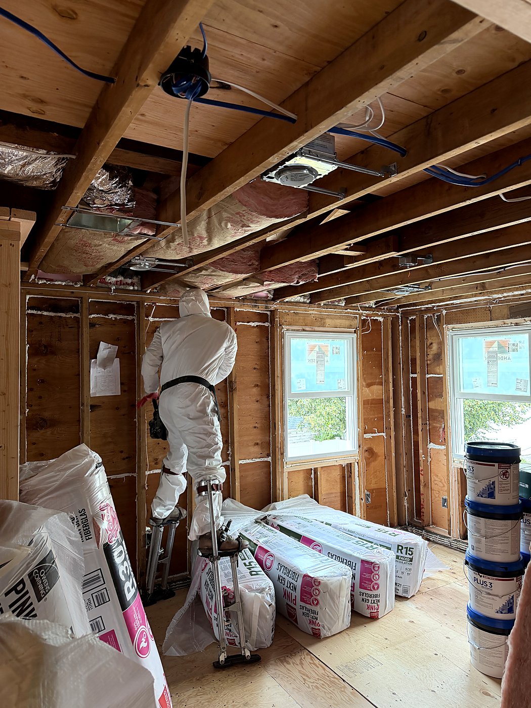 Crew member insulating the walls during the rough-in stage