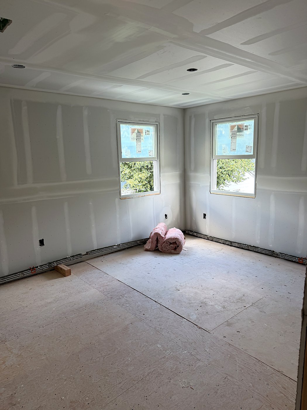 Bedroom with drywall hung around the new windows