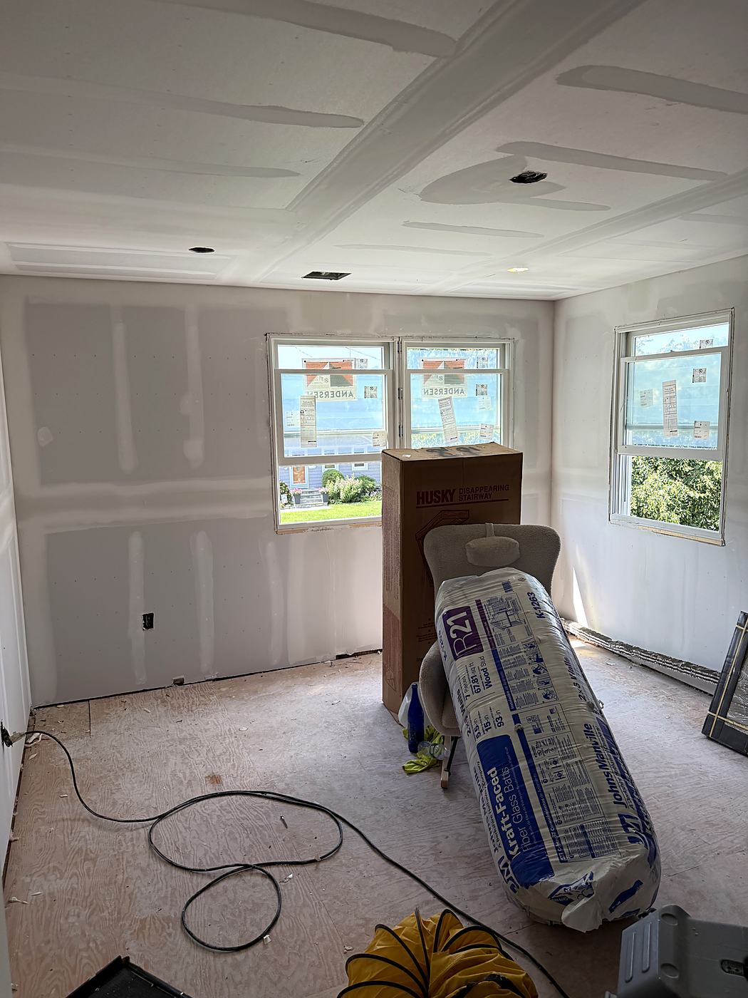 Bedroom drywalled and taped with a coffered tray ceiling above the new windows