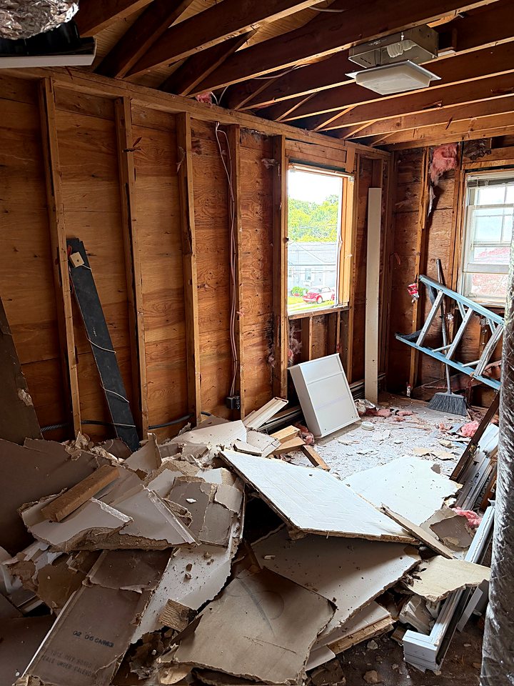 Demolition debris piled in a bedroom stripped to the studs