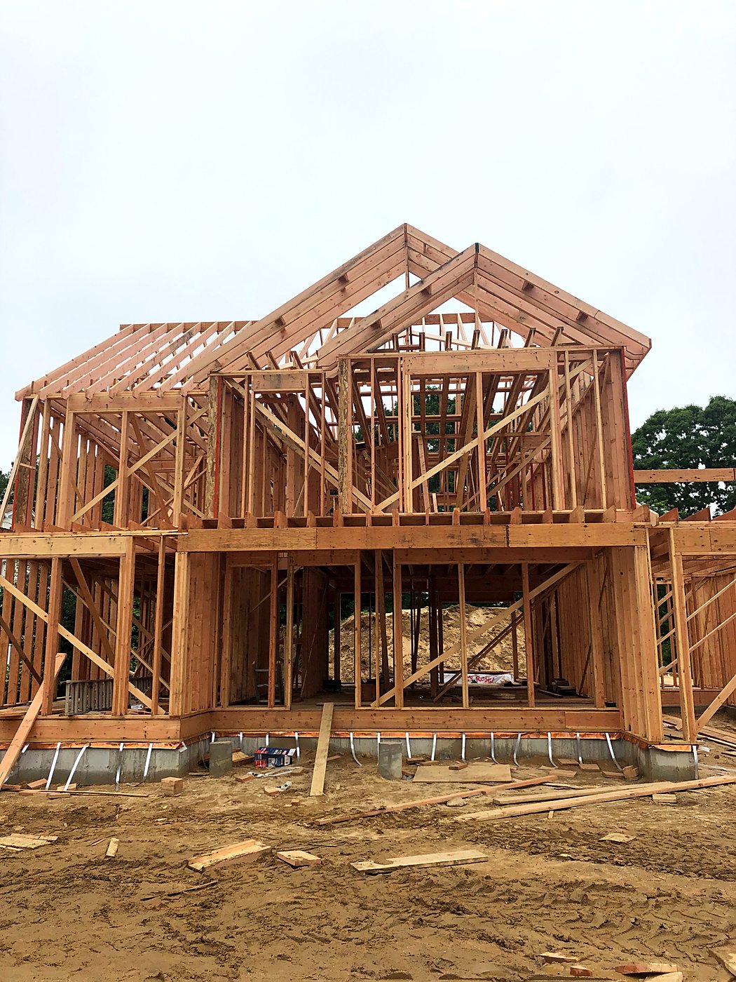 The custom home at full framing with the roof rafters and gable trusses set