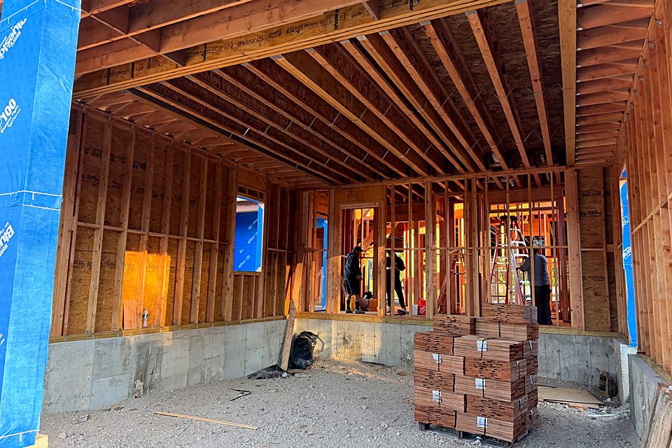 Crew working inside the framed first floor of the custom home