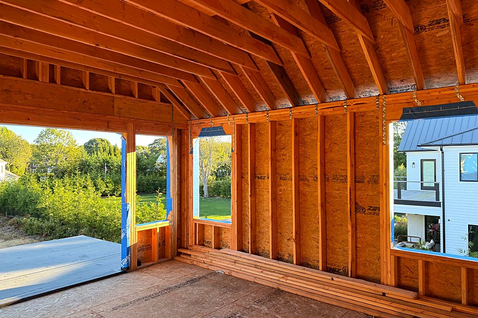 Great room framed with tall openings looking out to the yard
