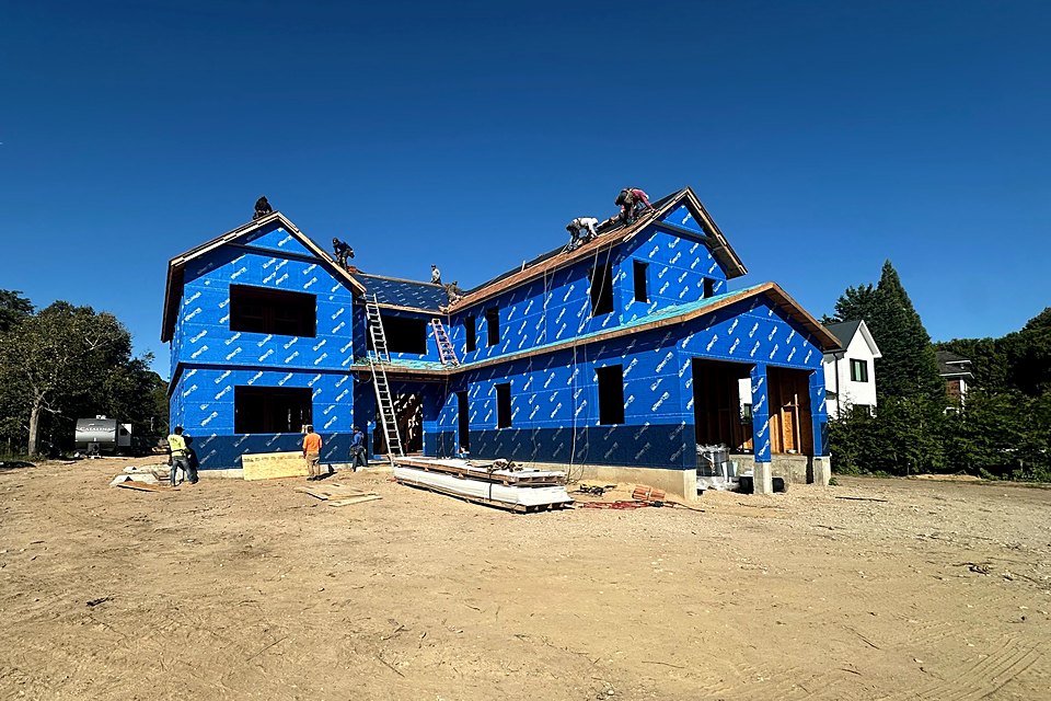 Wide view of the custom home fully wrapped and ready for windows