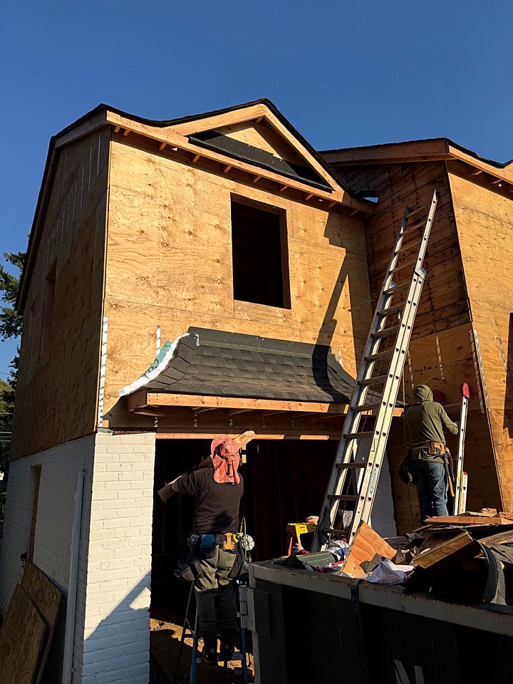 Crew working at a first-floor opening on the sheathed custom home