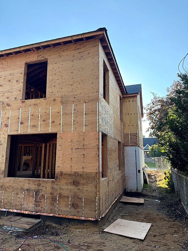 Side elevation of the custom home in plywood sheathing with copper base flashing