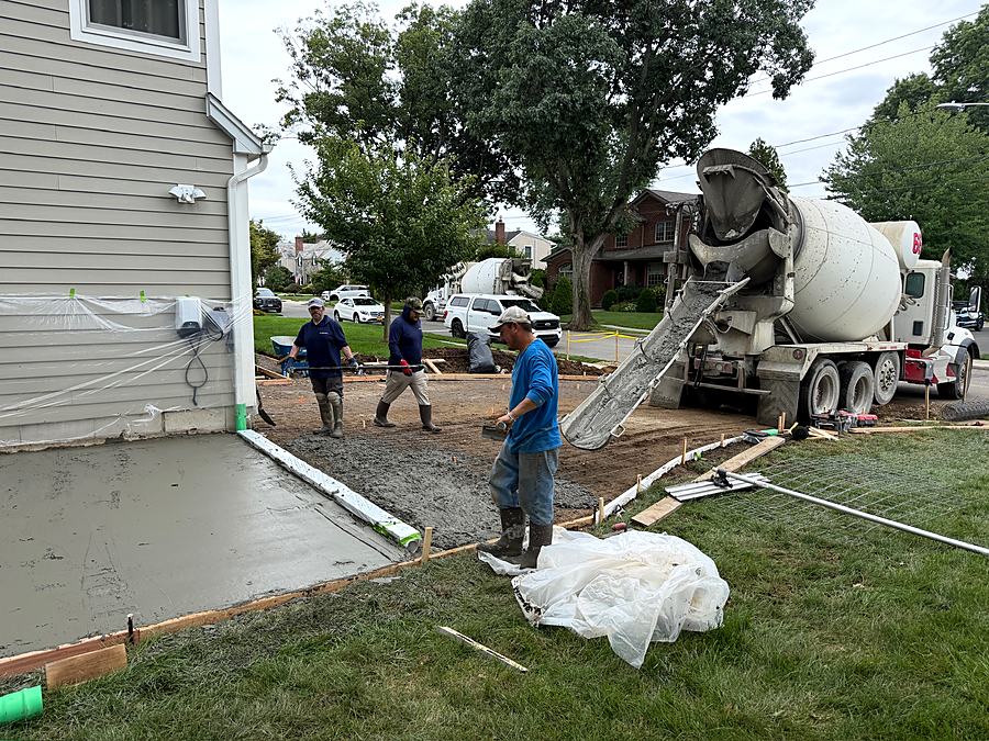 Concrete truck placing the new apron with the crew working the pour