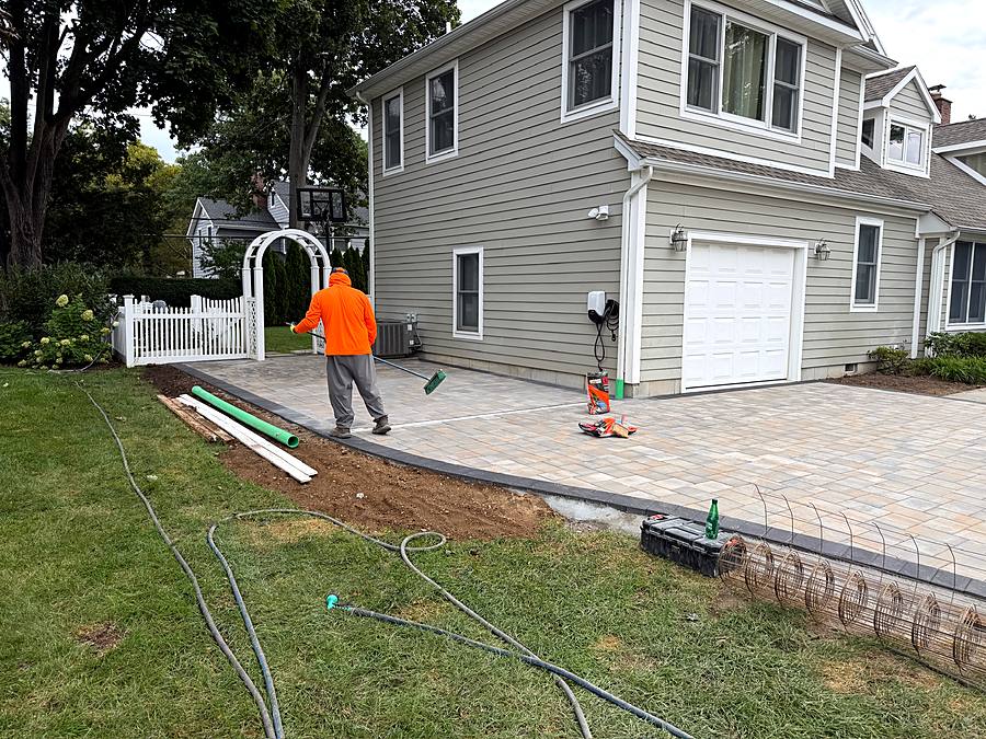 Crew setting the border course along the edge of the paver driveway