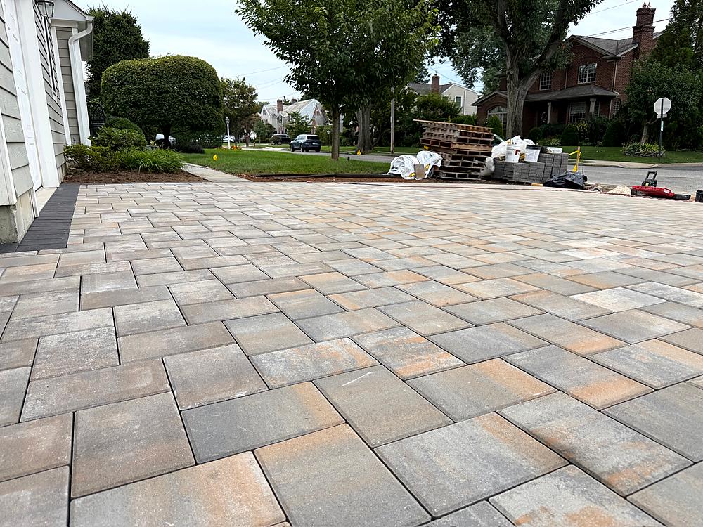 Finished paver driveway running to the garage with a new border course