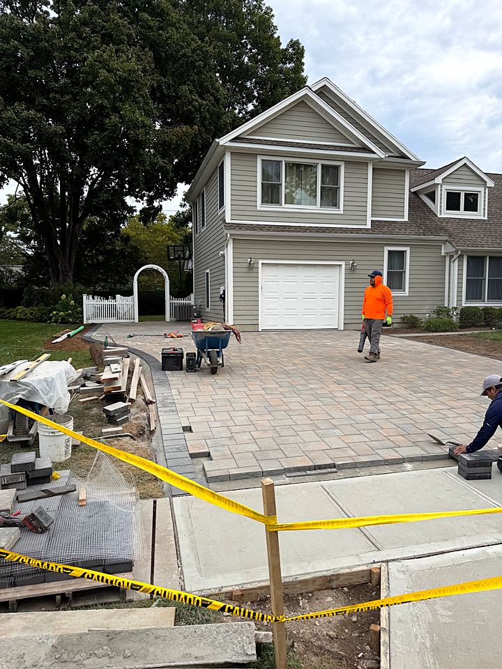 Crew finishing the paver field in front of the garage