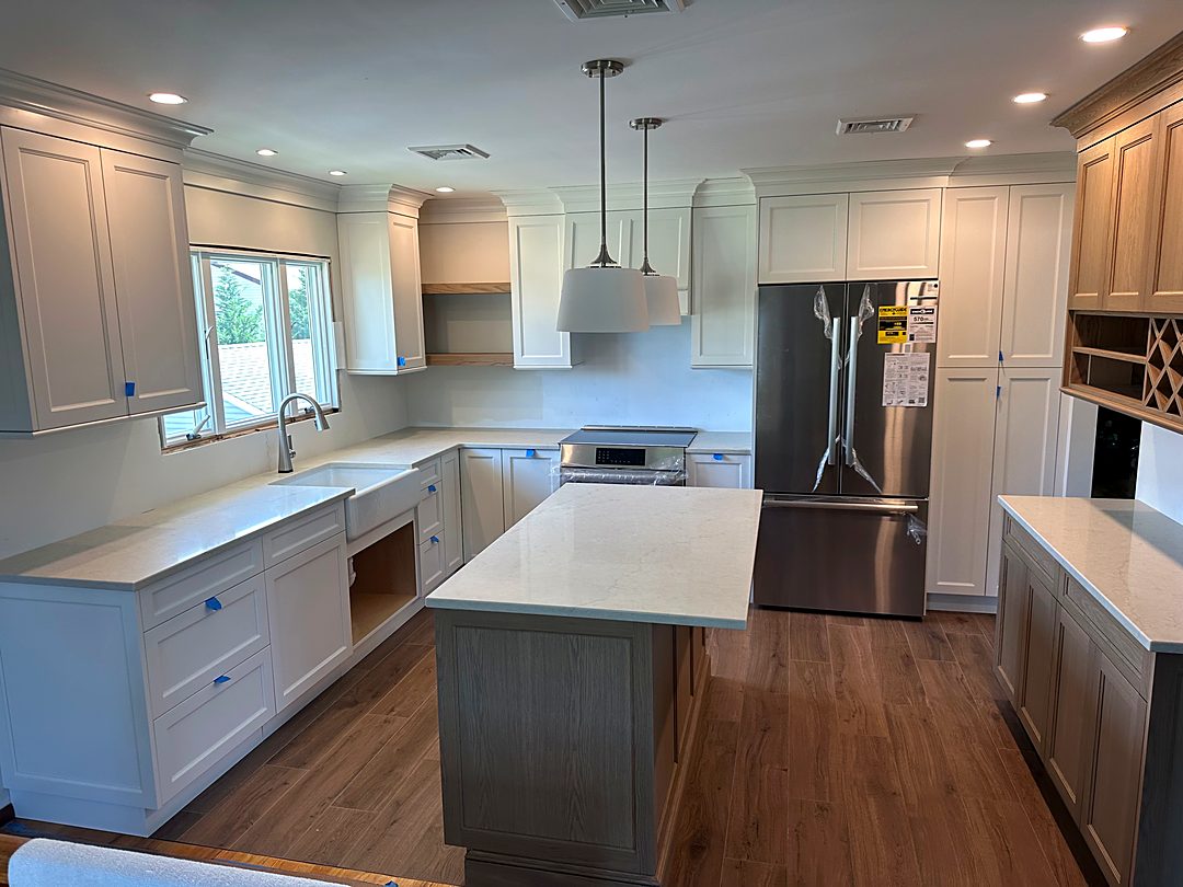 Kitchen with new quartz countertops, a center island, and appliances in place before final trim