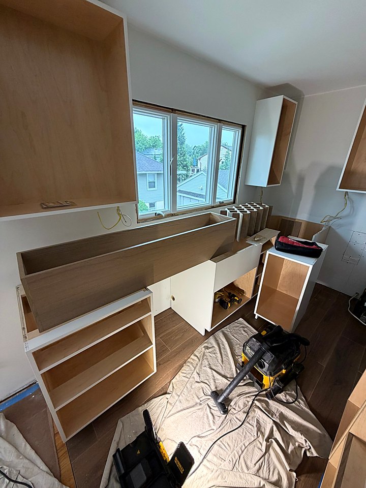 Upper and base cabinet boxes going in under the kitchen window
