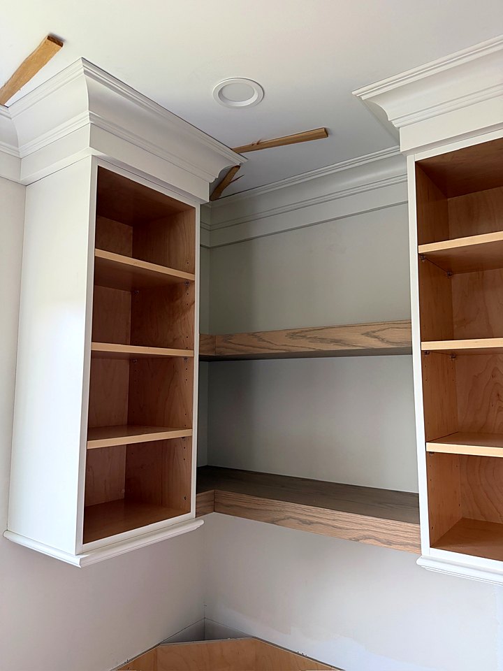 Tall open-shelf cabinets set on either side of a built-in nook